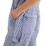 Mono largo con estampado geométrico en tonos celeste y blanco. Tiene tirantes finos, corte holgado y bolsillos delanteros.