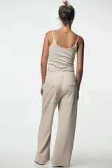 Pantalón de algodón color beige, de tiro medio, pierna ancha y cintura elastizada.