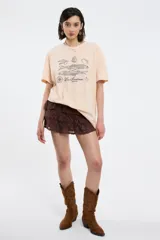 Remera color beige con estampado de sardinas, limones y aceitunas.