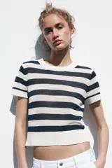 Top de punto celeste con rayas horizontales en azul. Tiene cuello redondo y mangas cortas.