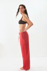 Pantalón de lino color rojo, de corte ancho y tiro alto, con cintura elástica ajustable con cordón.