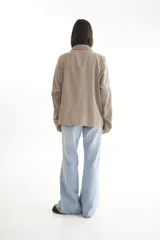 Camisa oversize color borgoña de pana con cuello camisero, cierre frontal con botones, dos bolsillos con solapa en el pecho y mangas largas con puños abotonados.