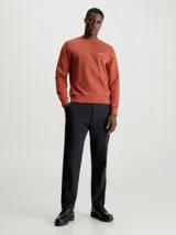 Buzo color ladrillo de algodón y poliéster con cuello redondo, puños y bajo acanalados. Presenta un pequeño logo de Calvin Klein en el pecho.