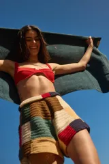 Short tejido a crochet con bloques de colores en tonos beige, marrón, verde, rojo y azul.