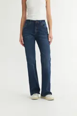 Jean de mezclilla azul oscuro, tiro alto, con corte acampanado (estilo Oxford o bootcut) y roturas sutiles en los muslos.