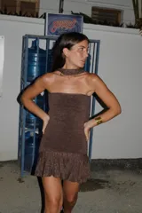 Vestido corto strapless color marrón con brillos, ajustado al cuerpo con tablitas y cierre en la espalda.