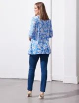 Blusa amarilla estampada con motivos florales en blanco, escote en V y mangas tres cuartos.
