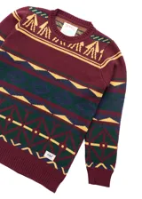 Buzo de punto color borgoña con cuello redondo y diseño geométrico multicolor.