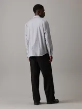 Camisa de vestir gris claro de corte regular, confeccionada en tejido Oxford de algodón y elastano, con cierre frontal abotonado, mangas largas y logo CK bordado en el pecho.