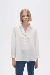 Blusa blanca holgada de poliéster con cuello camisero y mangas largas.