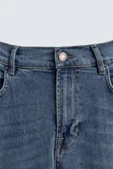 Pantalón de jean negro, corte slim fit, con tiro medio, cinco bolsillos, efecto lavado y cierre frontal con cremallera y botón.
