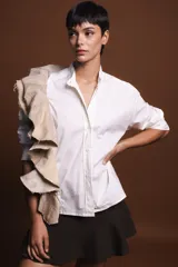Camisa beige de algodón con cuello mao y volado estructurado.