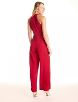 Enterito largo de crepe color rojo, con escote halter anudado y pierna ancha. Presenta bolsillos delanteros y abertura en la espalda con cierre invisible y botón.