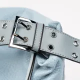 Bandolera celeste de cuero sintético con textura granulada, cierre superior y bolsillo externo con cremallera. Asa de hombro ancha con apliques metálicos.