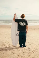 Remerón negro con efecto lavado y estampado en la espalda con la palabra "ALASSY" en letras amarillas con borde blanco, dentro de una forma geométrica.