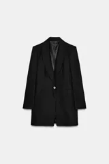 Blazer larga negra confeccionada en hilatura con lino, con bolsillos de vivo en delantero y cierre frontal con botón.
