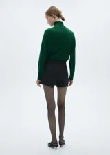 Sweater verde esmeralda de tejido de punto fino con cuello alto.