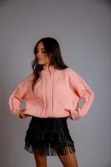 Sweater color crudo con cuello alto y diseño trenzado.