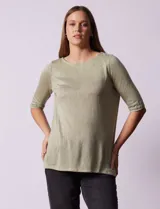 Remera verde con escote redondo y mangas tres cuartos. Presenta bordados en el escote.
