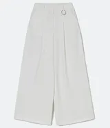 Pantalón largo de vestir color blanco, de corte palazzo, con pliegues frontales, bolsillos laterales y detalle de anilla metálica en la cintura.
