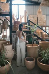 Pantalón de vestir negro de tiro alto, corte recto y pierna ancha. Presenta pliegues frontales y bolsillos laterales.