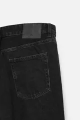 Pantalón de jean celeste de corte slim fit y tapered, con cinco bolsillos, efecto lavado y cierre frontal con cremallera y botón.