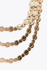 Collar dorado de tres hilos con monedas colgantes y cierre de mosquetón.