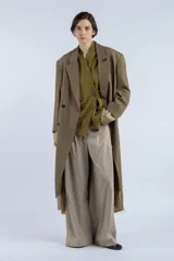 Tapado largo color verde oliva, de corte recto y silueta amplia, con diseño cruzado y cierre frontal de doble botonadura. Presenta solapas clásicas, hombros estructurados y largo por debajo de la rodilla. Confeccionado en lana y algodón.