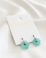 Aros de acero con dije de flor de acrílico color celeste.