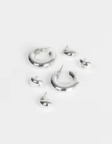 Set de tres pares de aros dorados: un par de aros tipo botón con forma irregular, un par de aros colgantes con forma de lágrima y un par de aros tipo argolla gruesa.