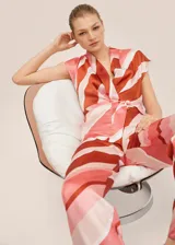 Mono largo de poliéster con estampado a rayas horizontales en tonos rosa, blanco y marrón. Tiene cuello en V, mangas cortas y lazo en la cintura.