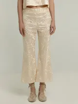 Pantalón de algodón color crema con estampado geométrico en relieve, corte flare y cintura alta elástica.