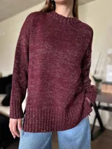 Sweater negro con hilo de lúrex plateado, de silueta holgada y cuello redondo a la base.