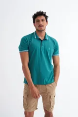 Polo de algodón color verde con rayas, corte clásico y media cartera de botones, con bordado en el pecho.