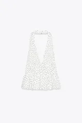 Top negro de cuello halter y escote pico con volantes en el bajo.