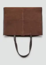 Bolso tipo shopper de piel de serraje color marrón, con diseño de paneles cosidos en el frente y bordes ribeteados en cuero liso oscuro. Posee dos asas de hombro de cuero liso oscuro y cierre de botón magnético.