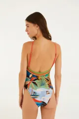 Malla entera con estampado de palmeras, tucanes y personas en la playa. Tiene tirantes finos ajustables y escote halter.