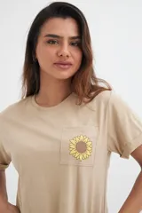 Remera color beige de algodón con bolsillo en el pecho y estampado de girasol.