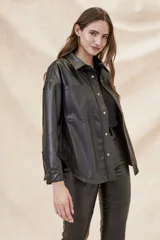 Sobrecamisa de cuero vegano negro, de corte oversize y cierre frontal a presión.
