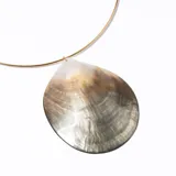 Collar rígido dorado con dije de ostra grande con reflejos nacarados.