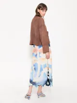 Pollera larga de satén bondeado doble con estampado personalizado y bordados de hilo con calados en el ruedo.