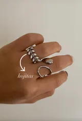 Anillo plateado con forma de rama con hojas blancas y anillo plateado liso.