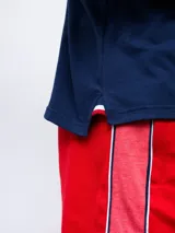 Remera polo azul con cierre, puños y cuello con detalle tricolor. Incluye logo de Umbro y escudo del Club Nacional de Football.