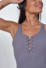 Catsuit deportivo gris con escote halter y cordones ajustables en el pecho.