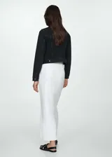 Chaqueta de jean negra con cuello clásico, cierre frontal con botones metálicos, dos bolsillos de parche en el pecho con botón, dos bolsillos laterales y mangas largas con puños abotonados.