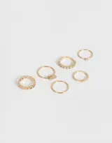 Set de 6 anillos dorados con diferentes diseños, algunos con strass y uno con dije de corazón.