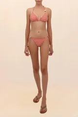 Calzón de bikini reversible, color rojo con estampado de hojas blancas. Tiene tiras laterales con cuentas decorativas.