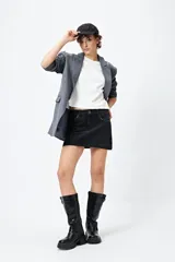 Minifalda de jean celeste con tiro bajo y detalle de tachas metálicas en los bolsillos.