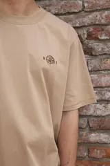 Remera color arena de algodón, corte clásico y mangas cortas.