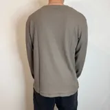 Buzo negro de micropanal con cuello redondo y mangas largas.